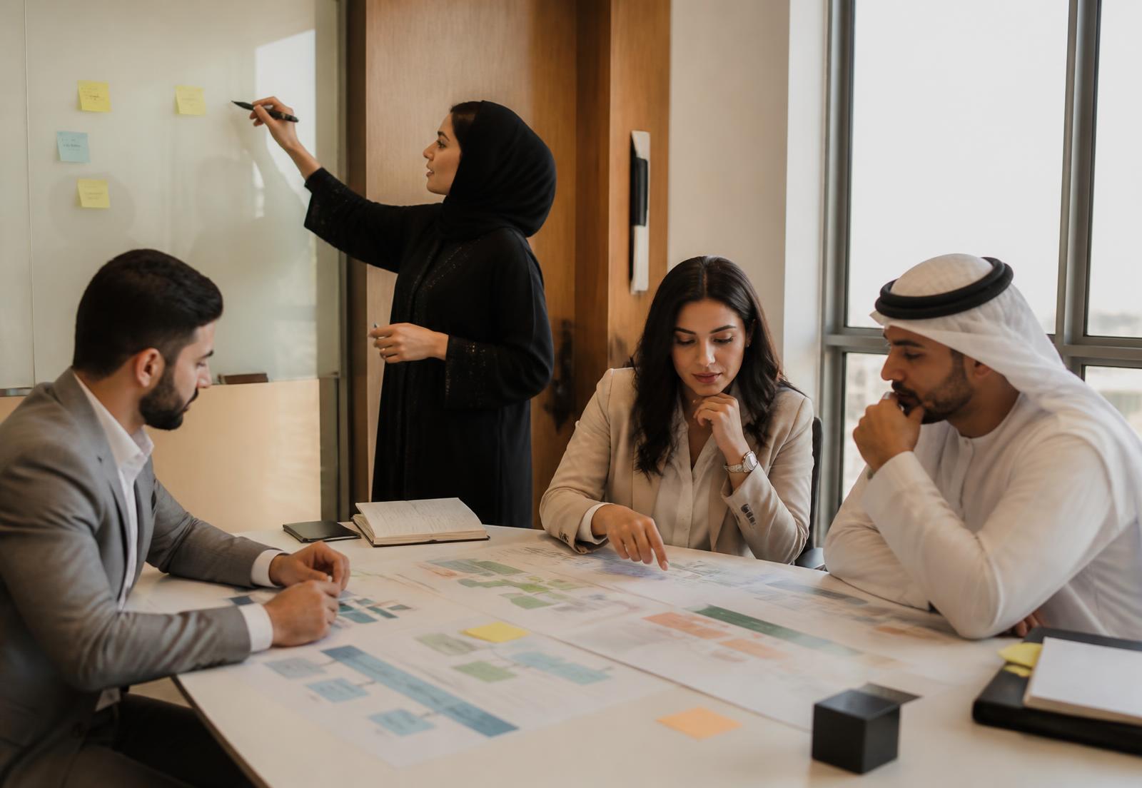 Consultants and managers working through printed role-definition worksheets during an employer workshop